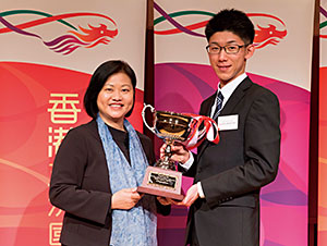 翁佩雯（シェーリー・ヨン）首席代表（写真・左）から香港杯を受け取る優勝者の児玉邦宏さん